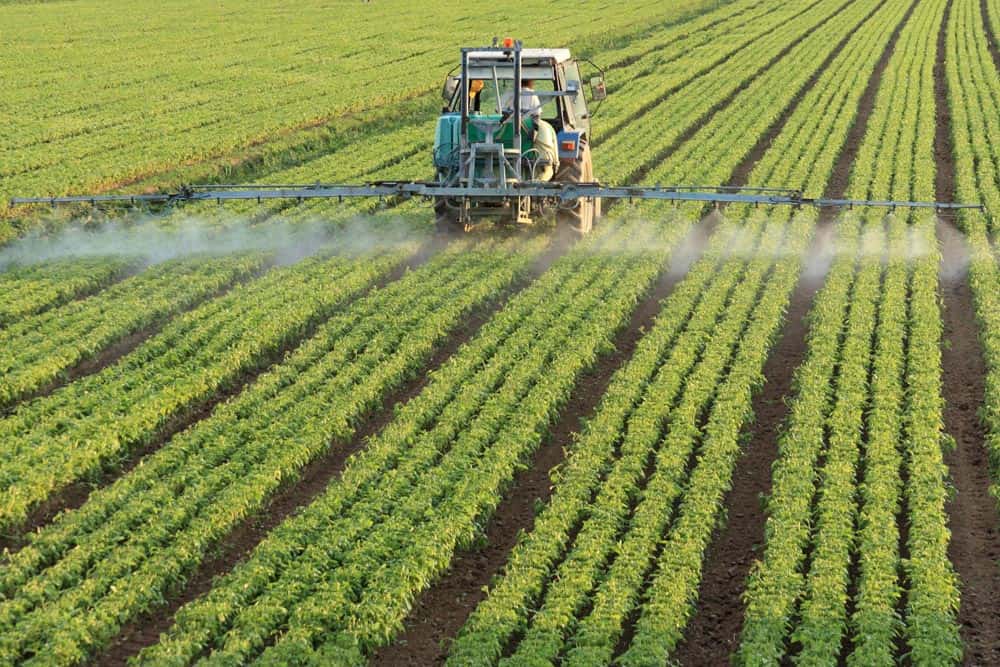 Tractor spraying crops in a field